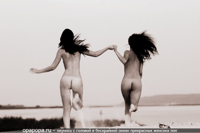 Черно-белая фотография: темноволосые подружки голышом на пляже трясут своими небольшими попками